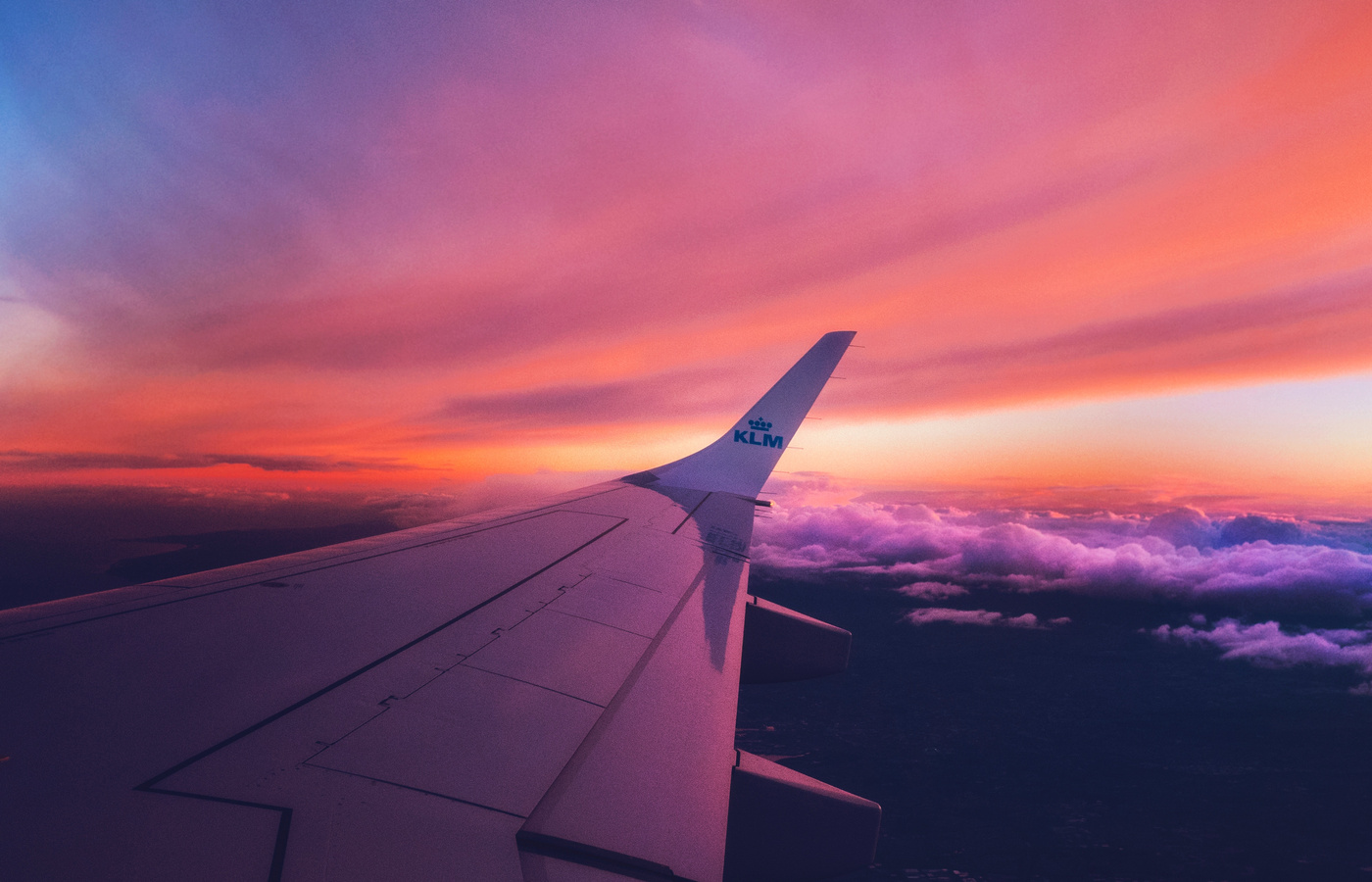 View from an airplane window above the clouds at sunset